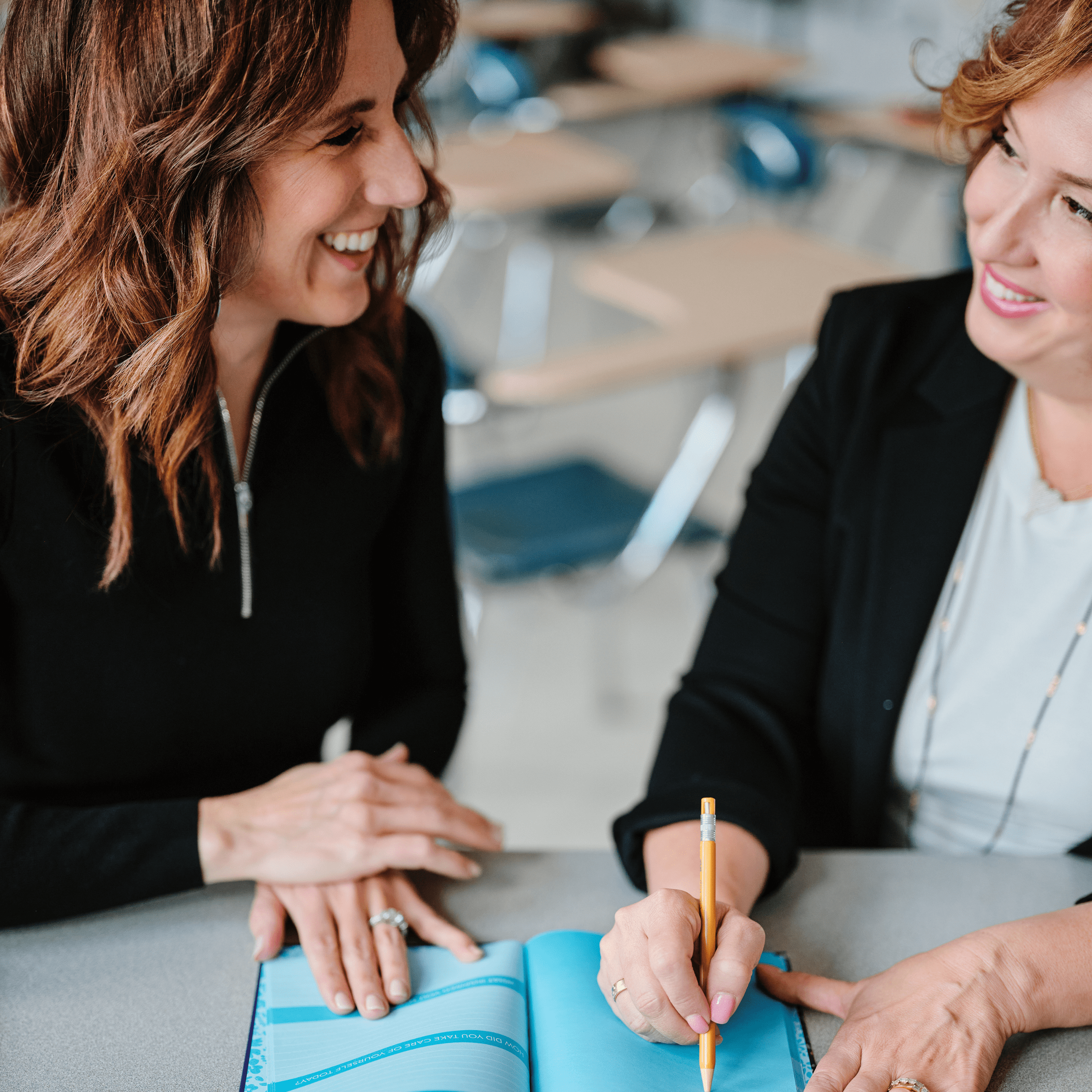 Dr. Julie and Dr. Kristie collaborate while looking over an Individualized Education Program (IEP), their focused expressions reflecting their dedication to ensuring inclusive and personalized support for students with diverse needs.